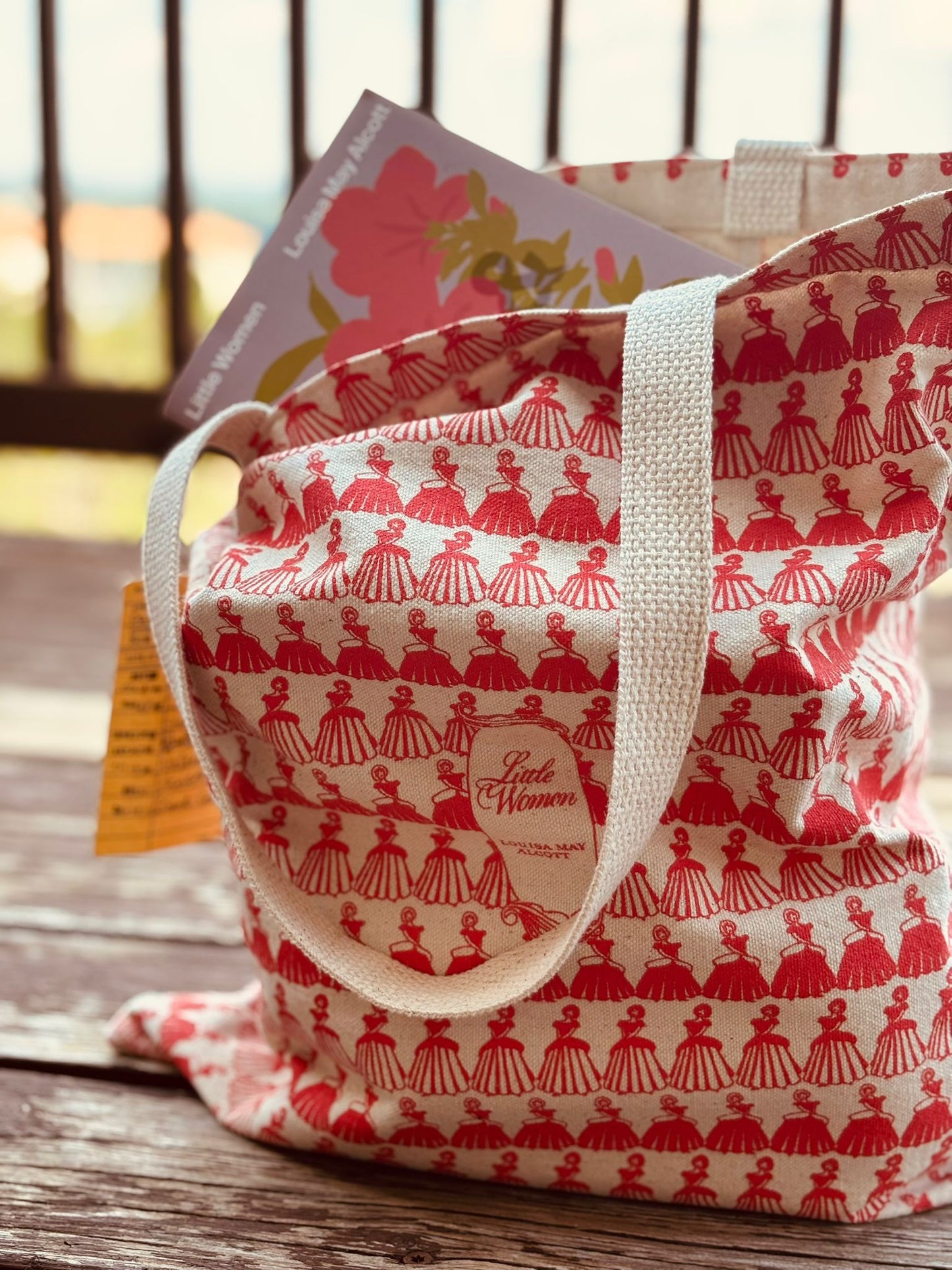 Red and white patterned tote bag on a wooden surface with a blurred background
