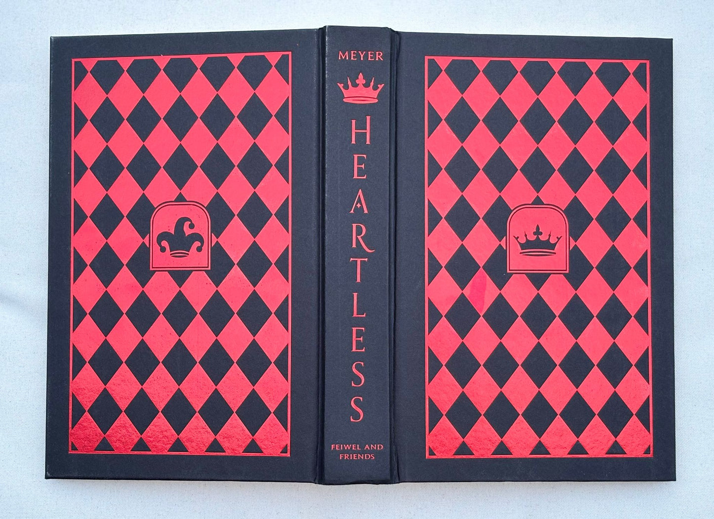 Book titled 'Heartless' with red and black diamond pattern on a light blue background